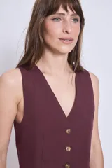 Chaleco color borgoña con escote en V y cierre frontal con botones dorados.