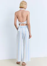 Pantalón de tiro medio con diseño culotte y estampado de rayas verticales celestes y blancas. Cuenta con trabillas, cinturón ajustable incorporado y cierre oculto.