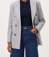 Bermuda long de jean azul con tiro alto, cintura con pasacintos, cierre con botón y cremallera, bolsillos funcionales y pespuntes en contraste.