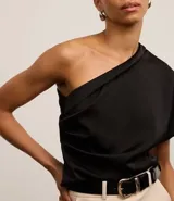 Blusa negra de crepé con drapeado lateral y hombro único.