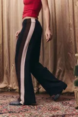 Pantalón tejido de corte recto y holgado, con cintura elástica. Presenta un diseño tricolor en los laterales con franjas verticales en negro, marrón y beige.