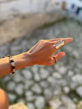 Anillo abierto de diseño rústico y orgánico, con textura irregular que evoca la naturaleza. Realizado artesanalmente en metal.