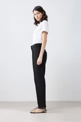 Pantalón de vestir color beige, de corte recto, con pinzas, bolsillos laterales y cinturón con hebilla forrada.