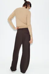 Pantalón de tiro alto con diseño tipo balloon, cintura con trabillas, bolsillos laterales y cierre frontal con cremallera y botón.