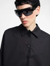 Camisa negra de algodón con botones en la parte delantera y cortes geométricos.