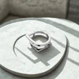 Anillo plateado de acero quirúrgico con diseño geométrico moderno.