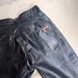 Pantalón de cuero vacuno negro, de tiro alto y corte recto con aberturas laterales en los bajos.
