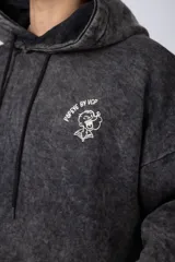 Buzo canguro oversize de algodón friza con efecto de teñido artesanal desgastado. Presenta capucha con cordones negros, bolsillo frontal tipo canguro y estampa pequeña de Popeye en el pecho.