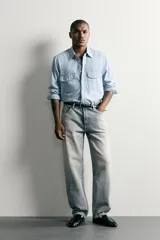Pantalón denim de corte recto desde la cadera hasta el tobillo, de tiro medio y color celeste claro con efecto lavado. Cuenta con diseño clásico de cinco bolsillos y cierre frontal con cremallera y botón metálico.