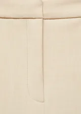 Pantalon de vestir de corte wideleg y tiro bajo, en color beige. Presenta trabillas para cinturón, bolsillos laterales y cierre oculto con botón, gancho y cremallera.