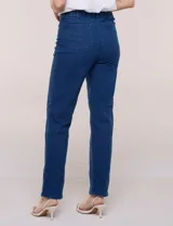 Jean straight elastizado de tiro medio, color azul, con bolsillos delanteros y traseros, pretina con pasadores, cierre y botón.
