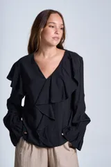 Blusa de color marrón con escote en V, mangas largas abullonadas con puños elásticos y detalles de volados en los hombros y el frente.