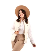 Chaleco capitoneado color crudo con cuello marrón y cierre frontal con botones a presión.