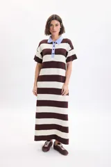 Vestido largo de punto a rayas horizontales en color marrón y beige, con mangas cortas y cuello polo celeste con botones negros.