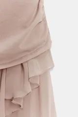 Vestido midi de algodón con cuello redondo y manga corta. Presenta un diseño combinado con cuerpo de punto y falda asimétrica con volantes, detalle de pliegues laterales y forro interior a tono.