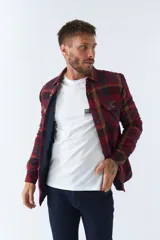 Sobrecamisa de viyela a cuadros rojos y azules con interior capitoneado, corte regular, manga larga, cierre con botones, bolsillos frontales y logo en grifa de cuero.