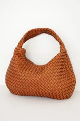 Bolso tipo hobo de cuero marrón oscuro, con diseño trenzado y asa integrada al hombro.