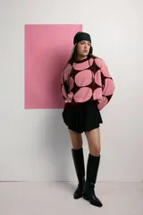 Buzo de tejido de punto color rosa con grandes círculos color borgoña.