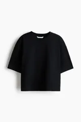 Remera de corte boxy en punto suave de algodón, con cuello redondo, hombros caídos y mangas cortas al codo.