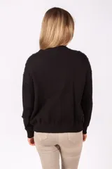 Sweater de punto negro con frente decorado con lentejuelas multicolor, cuello redondo y mangas largas con puños acanalados.