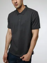 Chomba de manga corta Calvin Klein, confeccionada en mezcla de algodón y poliéster. Presenta cuello clásico, cierre frontal de dos botones y el monograma de la marca bordado sutilmente en el pecho.