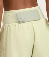 Bermuda deportiva de microfibra color azul petróleo, con diseño de doble capa que incluye un short interno ajustado y una capa externa suelta. Presenta cintura alta, bajo redondeado y bolsillo funcional en el short interno.