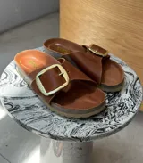 Sandalias de cuero color marrón con hebilla dorada y plantilla de cuero.