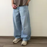 Pantalón jean de corte barrel, color azul clásico con efecto desgastado y diseño amplio y curvado en las piernas.