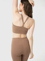 Conjunto deportivo compuesto por un top de escote redondo con espalda estilo nadadora y calzas de tiro alto con ajuste ceñido.