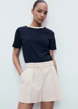 Short de corte recto color beige, con detalle de pinzas delanteras, bolsillos laterales y cierre oculto. Incorpora forro interior.