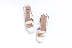 Zapato de cuero blanco con taco de madera, talón descubierto y pulsera con hebilla. Aplique decorativo en la capellada.