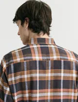 Camisa de franela de manga larga con estampado de cuadros escoceses, cuello button-down y cierre frontal con botones.