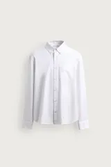 Camisa de manga larga regular fit en color marrón oscuro, confeccionada en tejido de algodón. Presenta cuello abotonado, bolsillo de parche en el pecho y cierre frontal con botones en contraste.