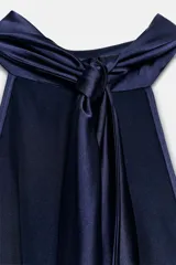 Vestido largo de satén azul marino con cuello halter y espalda descubierta. Presenta un cierre posterior con cremallera oculta y lazada en el cuello.