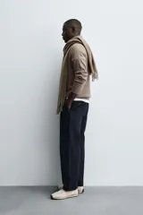 Polo de punto de corte regular fit, confeccionado en una mezcla de lana y cashmere. Presenta cuello solapa con cierre frontal de dos botones, manga larga y terminaciones en rib.