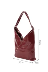 Cartera tipo hobo de cuero sintético negro con acabado brillante, decorada con tachuelas metálicas plateadas a lo largo de la correa y en la costura frontal diagonal.