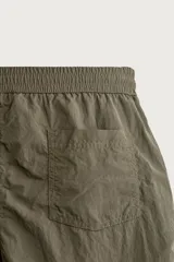 Short de baño de color azul marino, confeccionado en tejido técnico, con cintura elástica ajustable mediante cordón, bolsillos laterales y detalle de bolsillo trasero.
