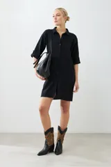 Túnica negra con bordados y bolsillos laterales.