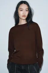 Jersey de punto liso color verde, con cuello redondo y manga larga. Confeccionado en hilatura de lana 100% con tacto suave.