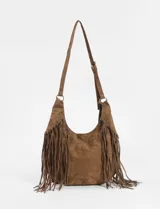 Cartera bandolera de estilo boho con flecos largos en los laterales. Cuenta con una correa ajustable con hebilla y herrajes metálicos en tono bronce.