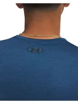 Remera deportiva Under Armour de manga corta, color azul con textura jaspeada y logo de la marca en contraste en el pecho. Presenta un corte holgado y tejido técnico transpirable.