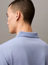 Chomba azul de poliéster con monograma de Calvin Klein, corte regular, mangas cortas y cuello polo con cartera de dos botones ocultos.