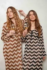 Vestido largo de lurex con diseño de patrón en zigzag en tonos tostado y marrón, escote en V con cordones para atar y mangas largas.