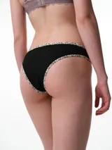 Bombacha tipo bikini de tiro medio confeccionada en algodón acanalado blanco, con bordes terminados en ribete con estampado animal print.