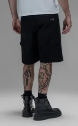 Bermuda de denim estilo carpintero con bolsillo lateral, confeccionada en algodón con efecto de desgaste y corte oversize.