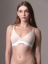 Bralette color beige de algodón y modal, con copas ligeramente acolchadas y sin costuras. Tiene clips de enfermería desplegables, correas de hombro ajustables, cierre de doble gancho y banda elástica inferior con logo Calvin Klein.