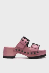 Sandalias de madera color rosa con plataforma y dos tiras de cuero rosa con hebillas negras.