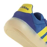 Championes Adidas Barreda Decode de estilo retro, con diseño inspirado en el calzado de fútbol. Presentan una combinación de colores azul y amarillo, con la clásica puntera en forma de T y las tres bandas laterales características de la marca. Cuentan con una mediasuela de aspecto translúcido y suela de goma.