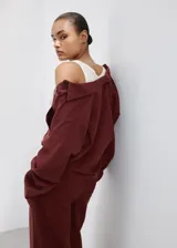 Camisa oversize color borravino, de manga larga con puños abotonados, cuello camisero, dos bolsillos de parche en el frente y cierre delantero con botones.