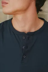 Remera azul marino de manga corta con cuello henley y tres botones.